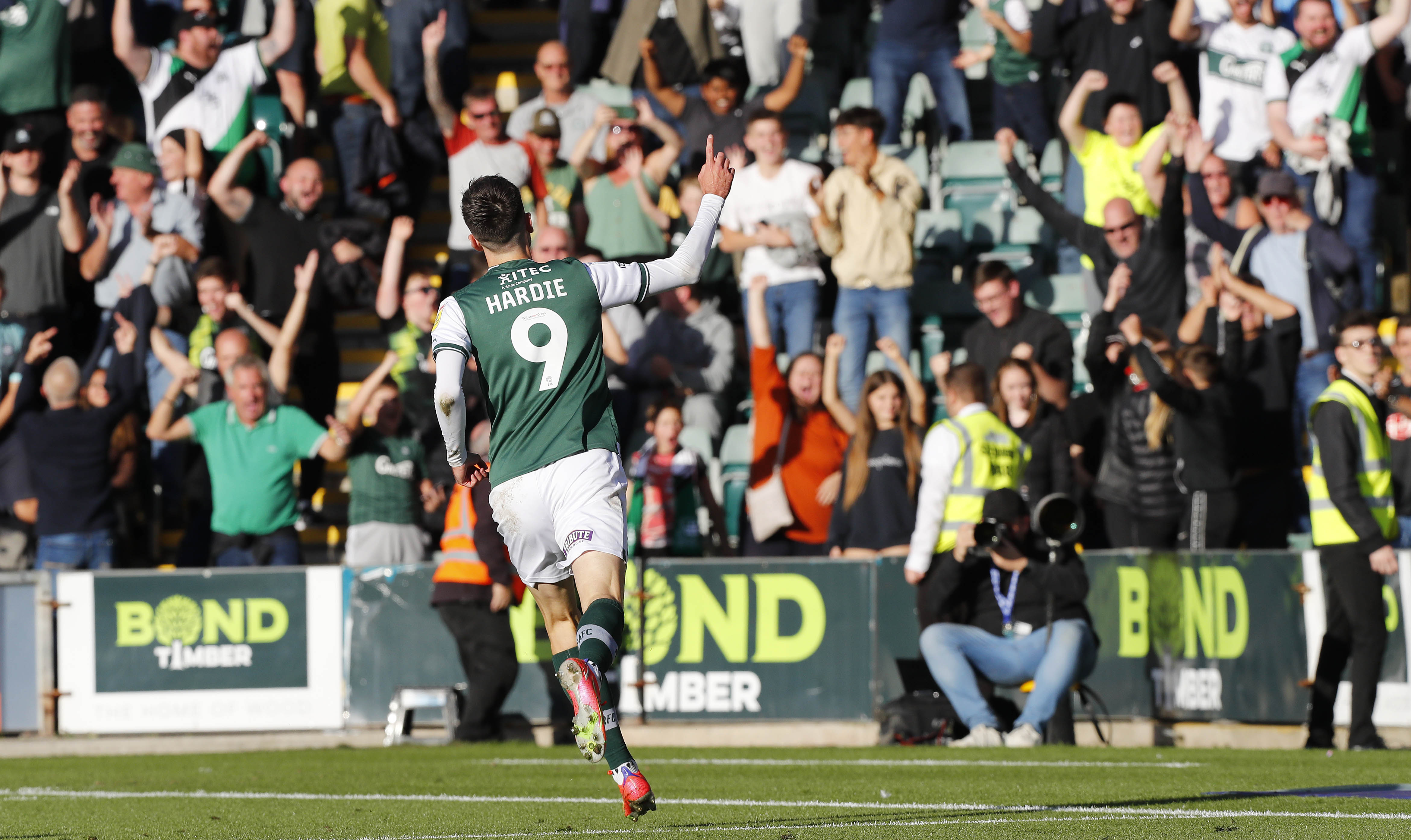 Ryan Hardie celebrates in front of Bond Timber advertising at Home Park