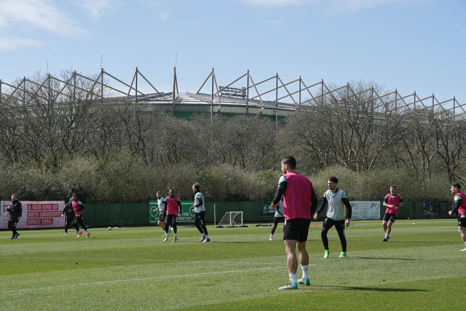 A wide shot of the group training with Home Park in the background.