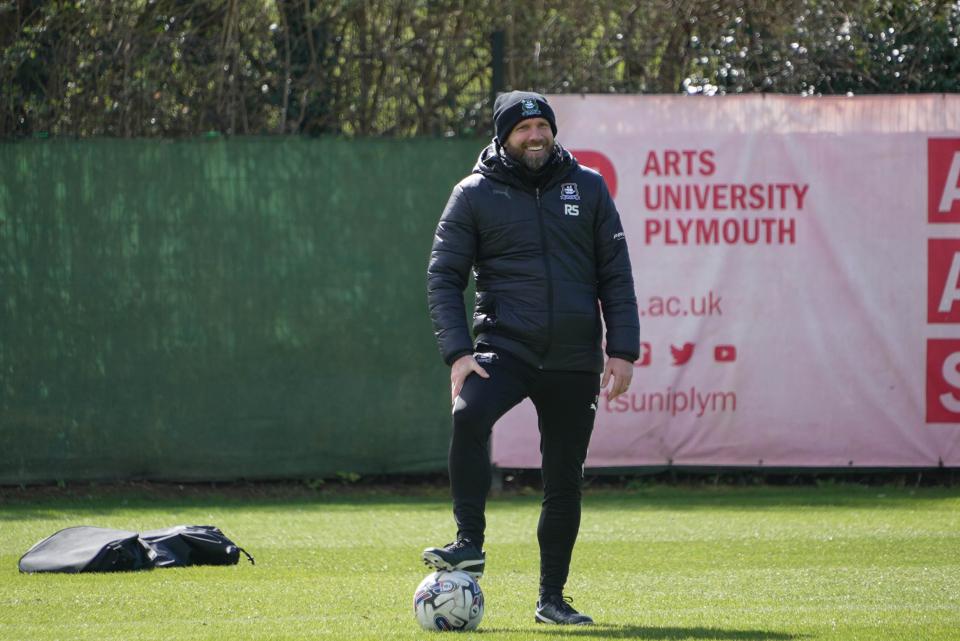 Ian Foster smiles while watching the players train.