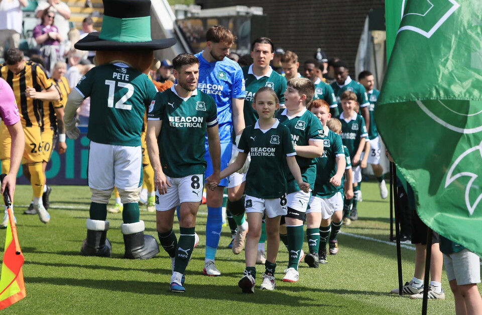 Joe Edwards walking onto the pitch with a mascot