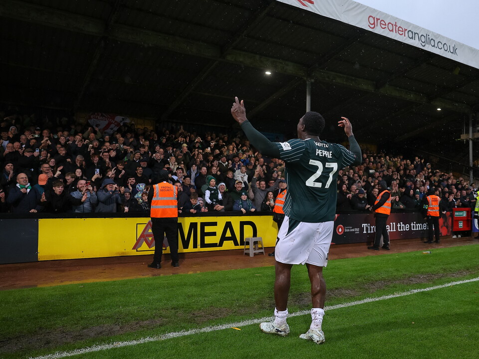Player with shirt number 27 celebrating on a football pitch with spectators.