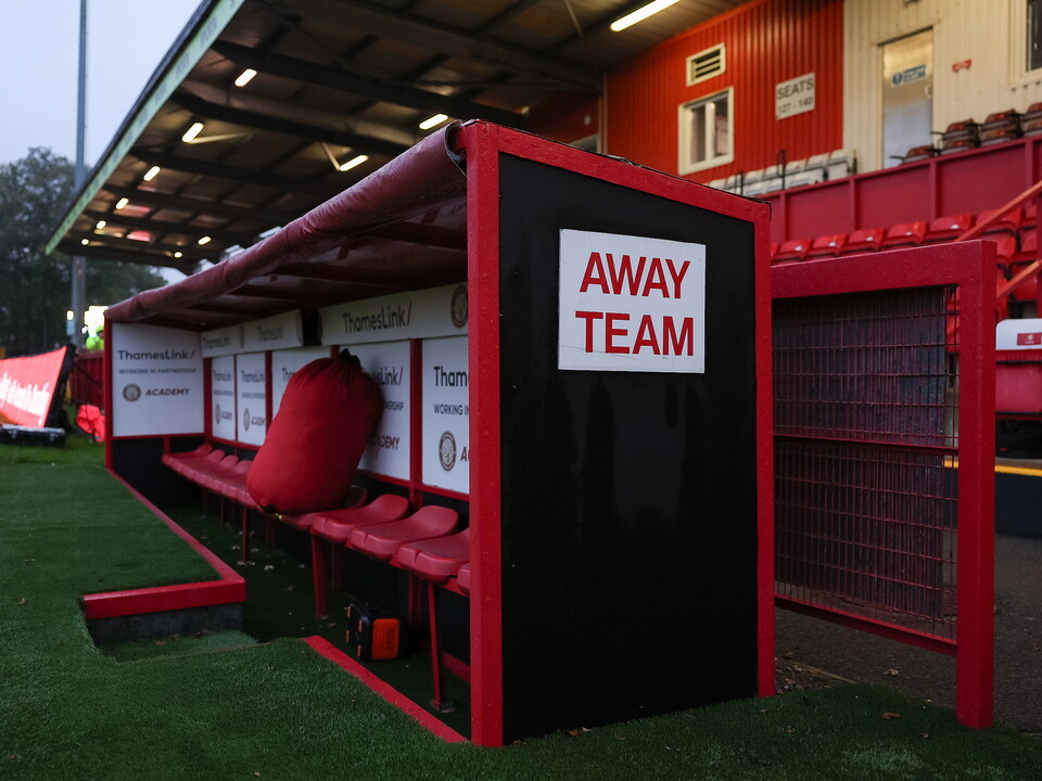 Away team changing room with red seating and white sign