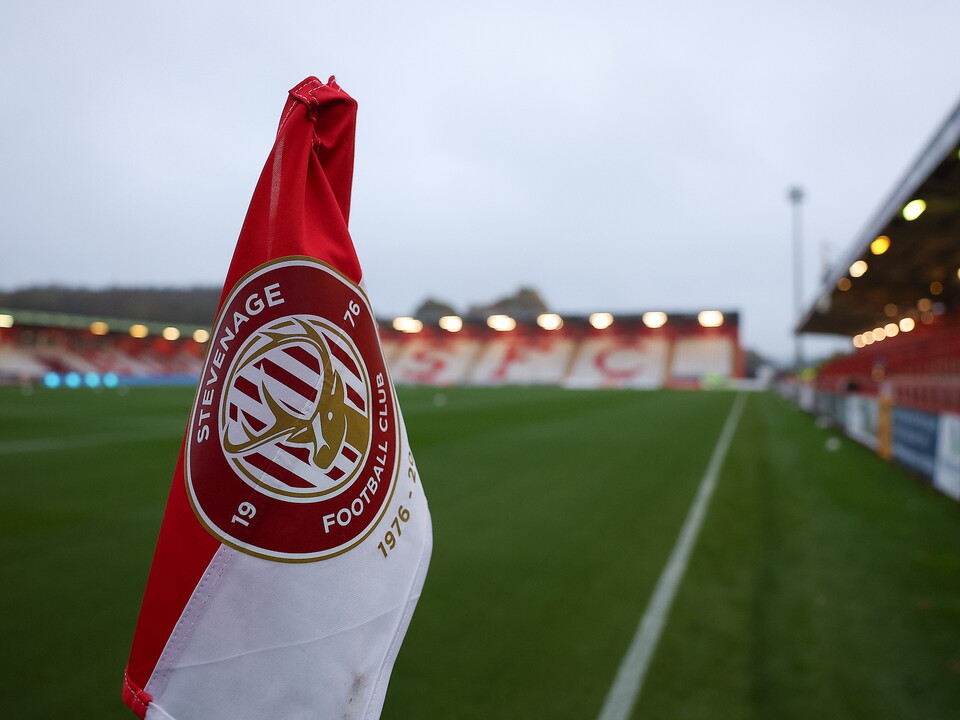 Empty football ground with red and white striped flag.