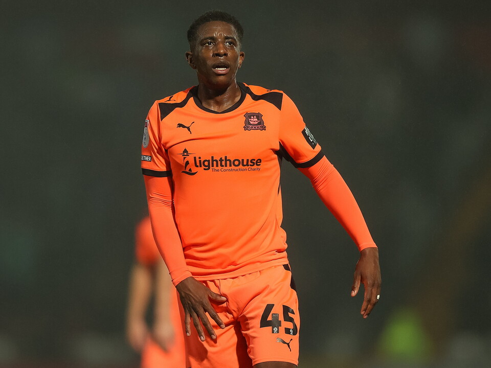 Footballer wearing number 45 orange shirt on the pitch, looking left.