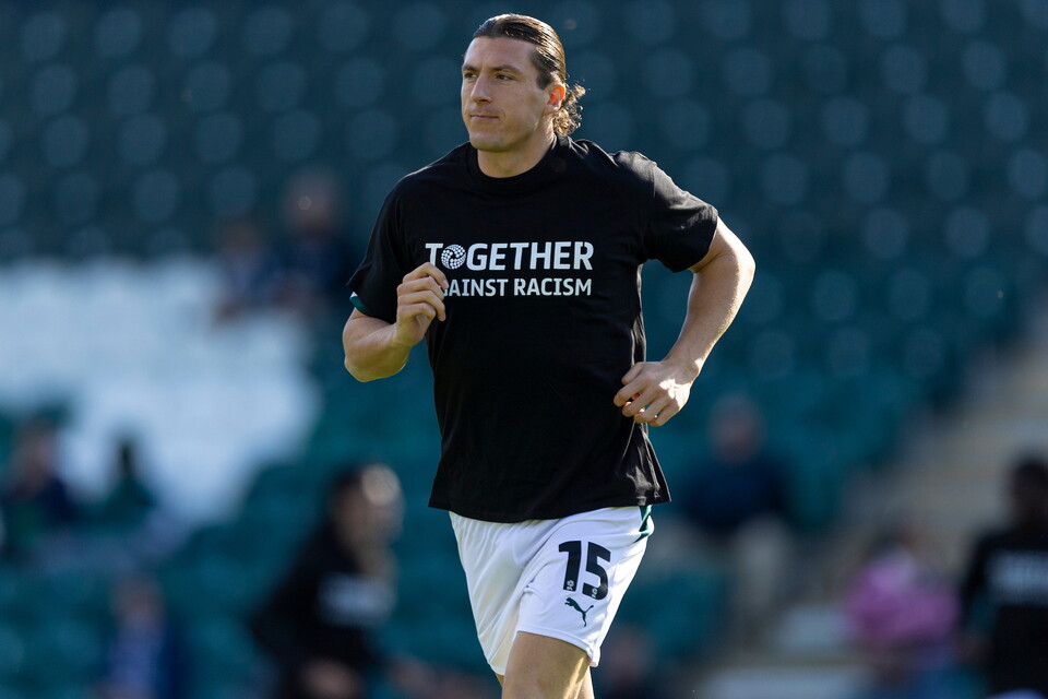 A football player runs with the number 15 on the back of his shirt.