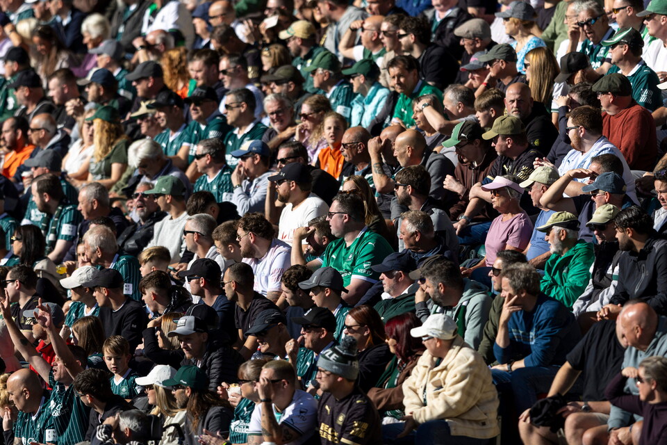 Large crowd at a stadium, most wearing green and white