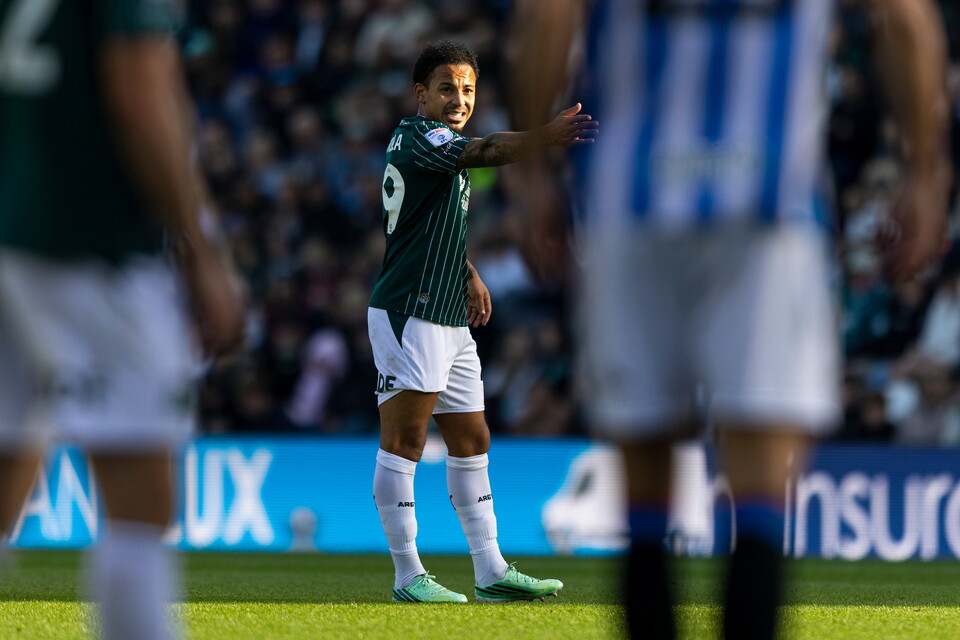 Footballer wearing green shirt, number 9, gesturing during a match.