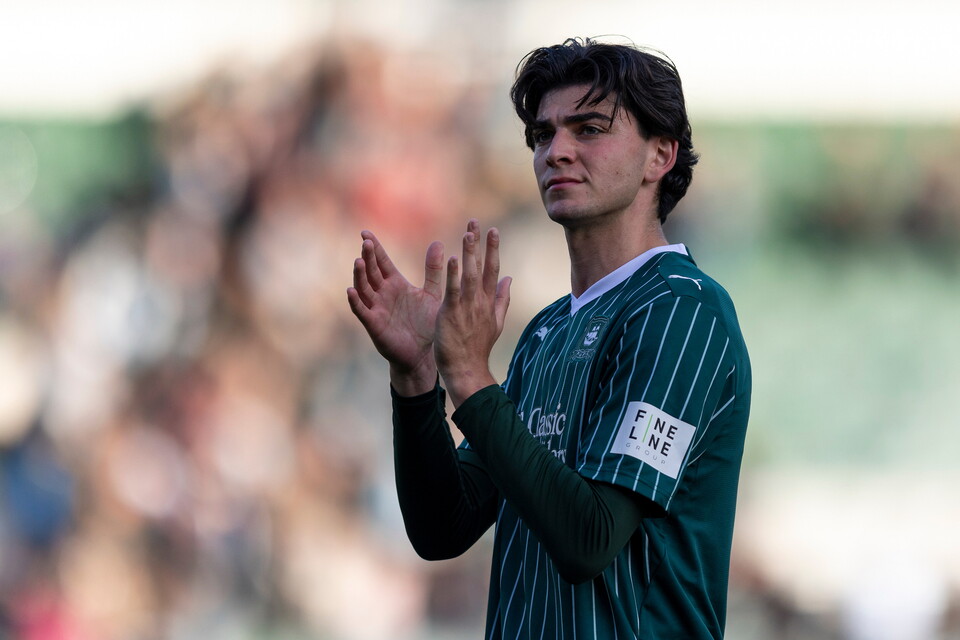 Football player clapping hands in green shirt, number 8 on back