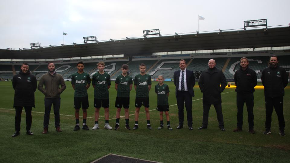 Academy players stand alongside proud sponsors at Home Park