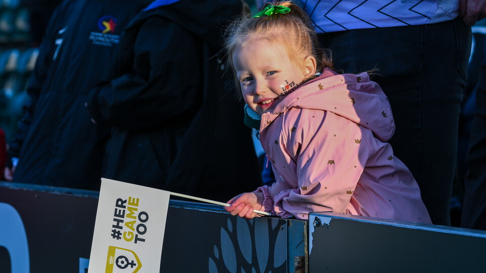 An Argyle fan holding a Her Game Too flag