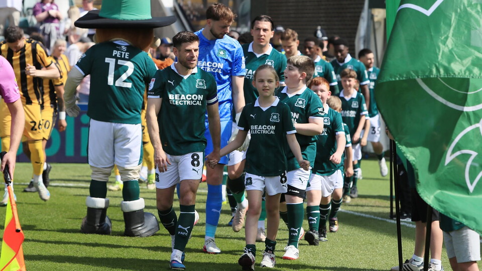 Joe Edwards walking onto the pitch with a mascot