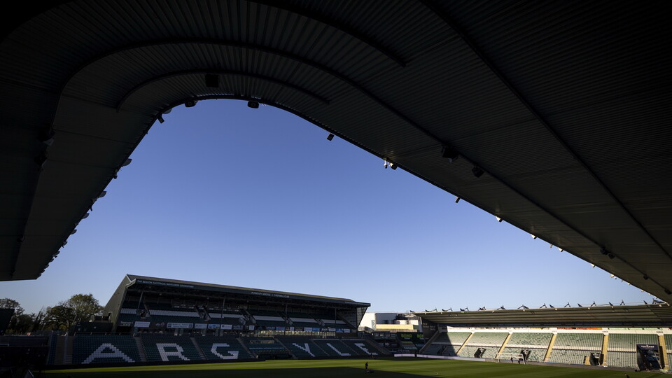 An empty stadium with a bright blue sky above.