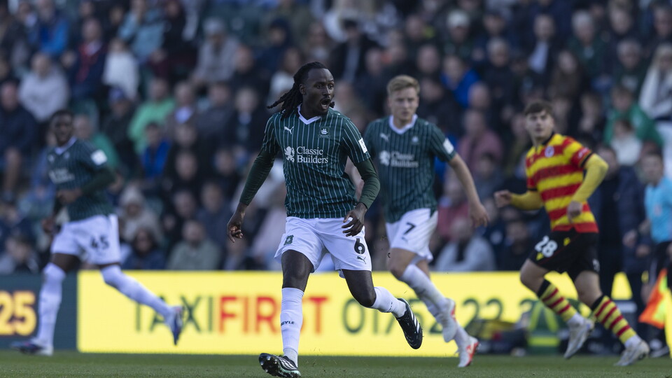 Players run across a pitch